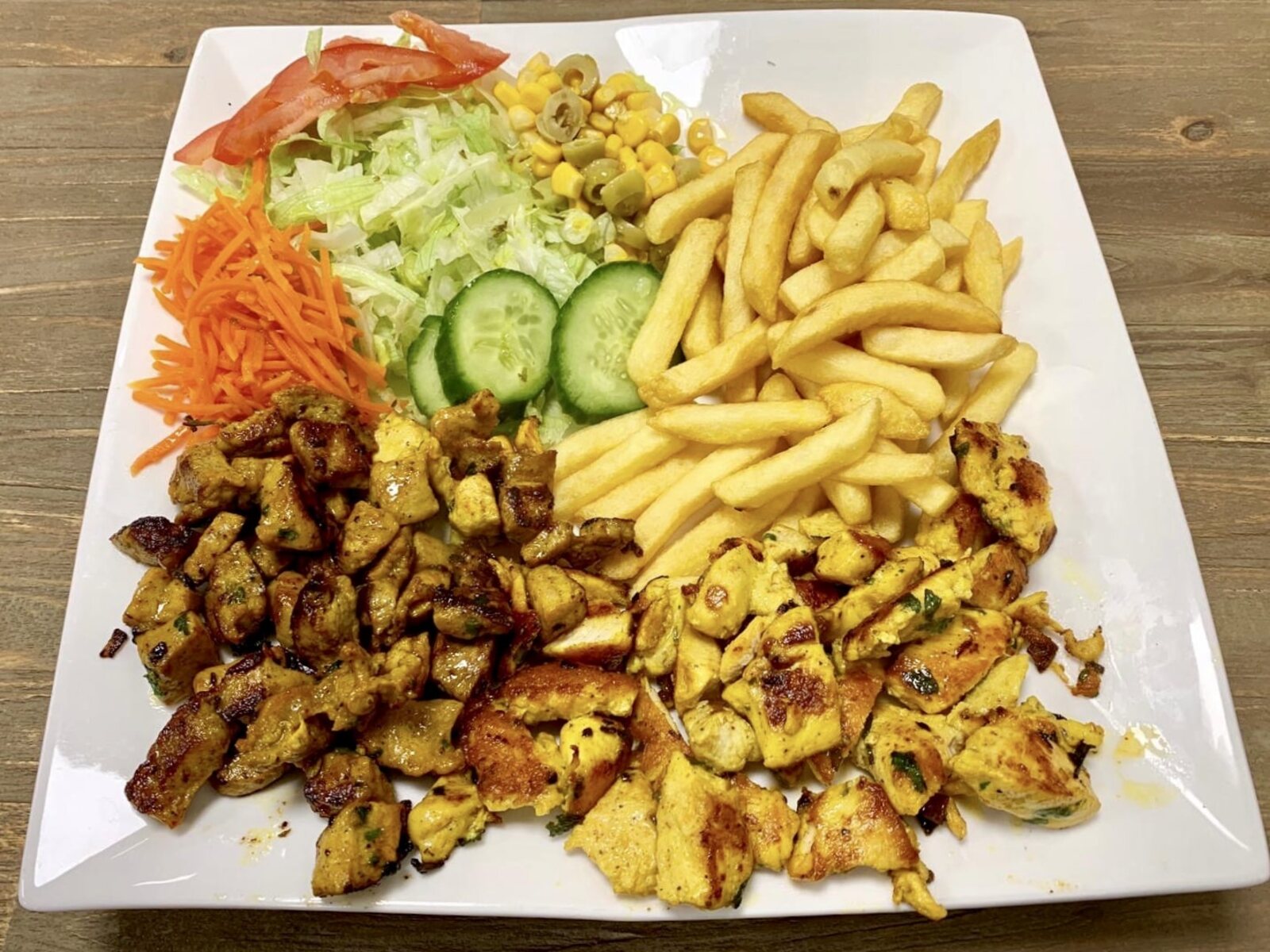 Royale mixgrill-schotel met vlees, friet en verse salade